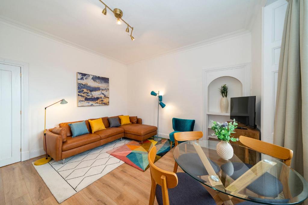 a living room with a couch and a glass table at Abbotsford Apartment in Dundee