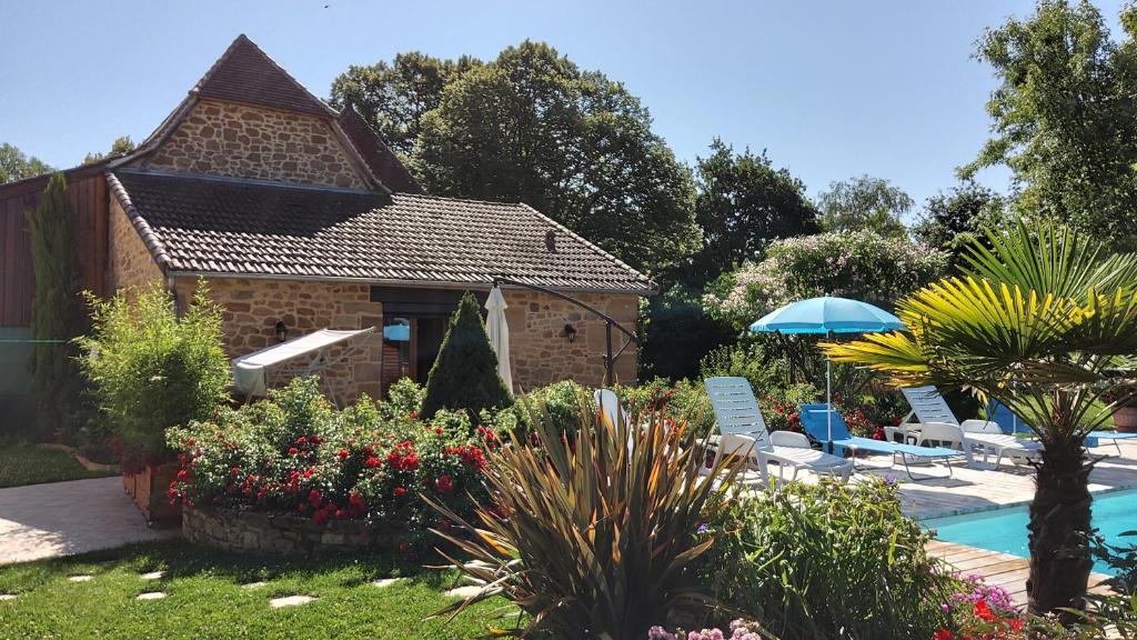 un jardín con piscina y sillas y una casa en LE POULAILLER DE LA CHAYRIE en Lacapelle-Marival