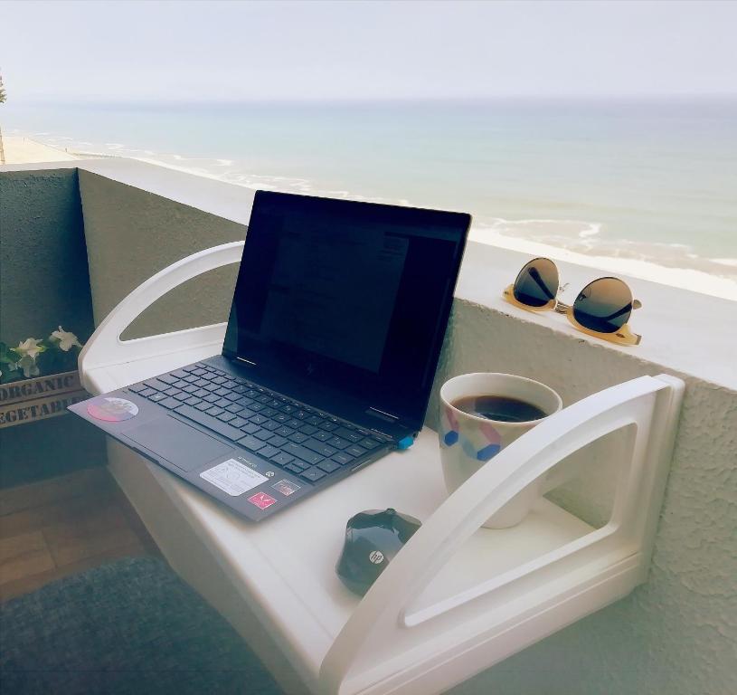 a laptop computer sitting on top of a white bench at EuVe Ocean View Flat in Lima in Lima