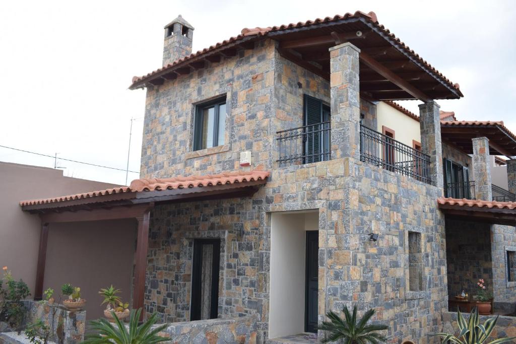 een stenen huis met een balkon erboven bij Rahati Holiday Villa Maisonette by Estia in Kerásia