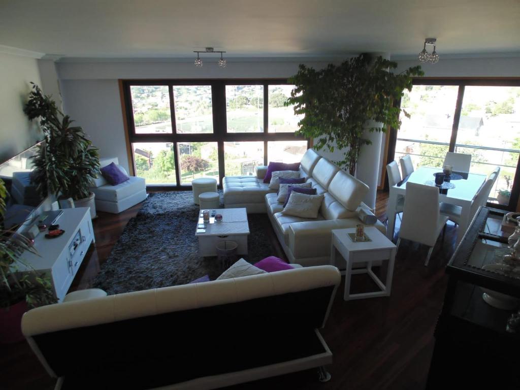 una sala de estar con sofás, mesas y ventanas en Duplex grandes cristaleras impresionantes vistas, en Ourense