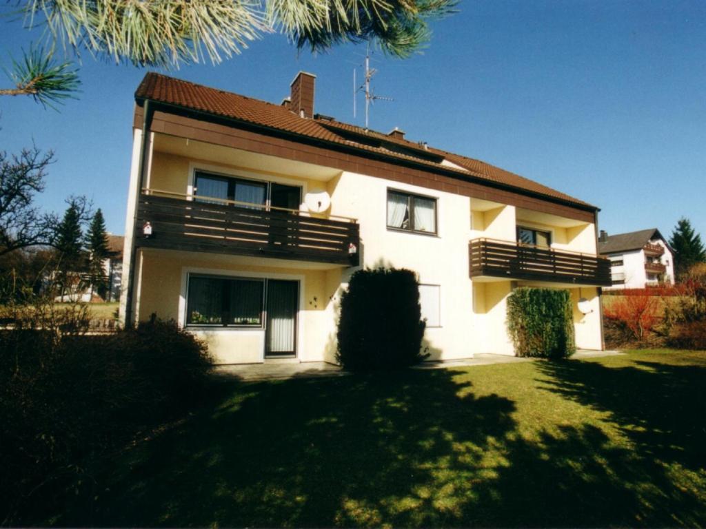 a house with a balcony on the side of it at Ferienwohnungen Am Park in Bad Steben