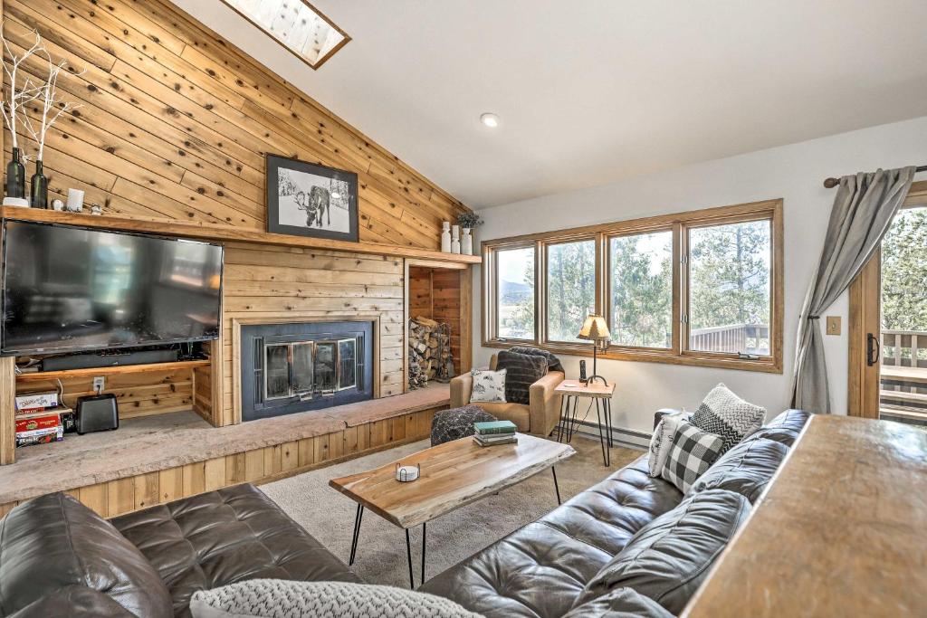a living room with a couch and a fireplace at Sunny Alpine Escape with Hot Tub and Mountain Vistas! in Fraser