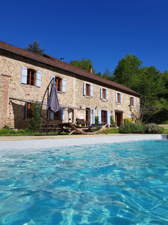 una casa con piscina frente a ella en Gites de La Soulière, en Aubin