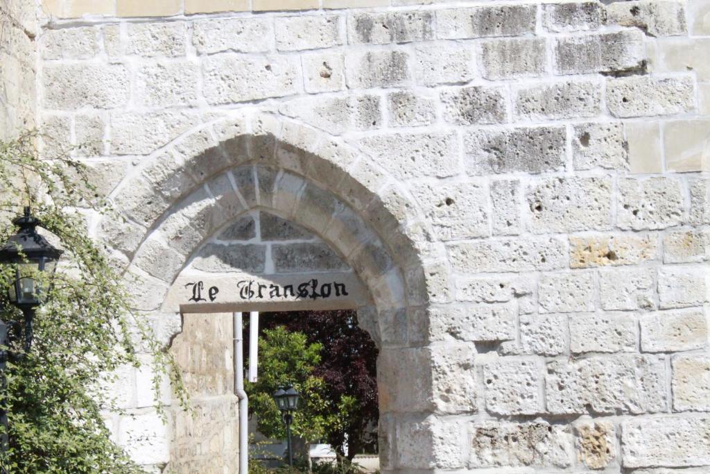 une arche dans un bâtiment en pierre avec un panneau indiquant l'entrée dans l'établissement Domaine Le Translon, à Saint-Pierre-Aigle