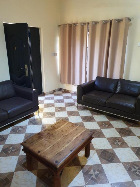 a living room with a couch and a coffee table at FANTASTIC APARTMENT, TRAVELER AWARD WINNER 2024, 1 ensuite bedroom, WIFI, air condition, separate living room, 2 toilets, 2 walk in shower rooms, hot water, separate kitchen, restaurant, bar, garden, 24 hour security, 20 minutes airport, North Legon Accra in Accra