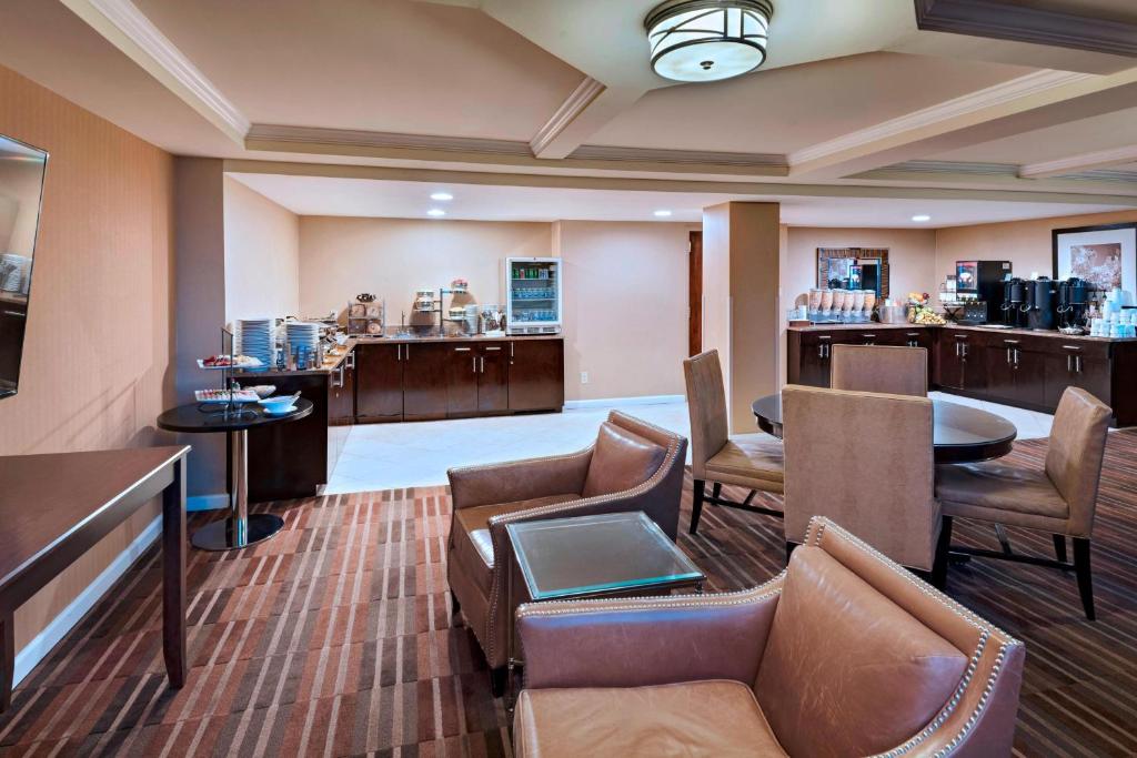 a hotel room with a waiting area with chairs and tables at Sheraton Pentagon City in Arlington