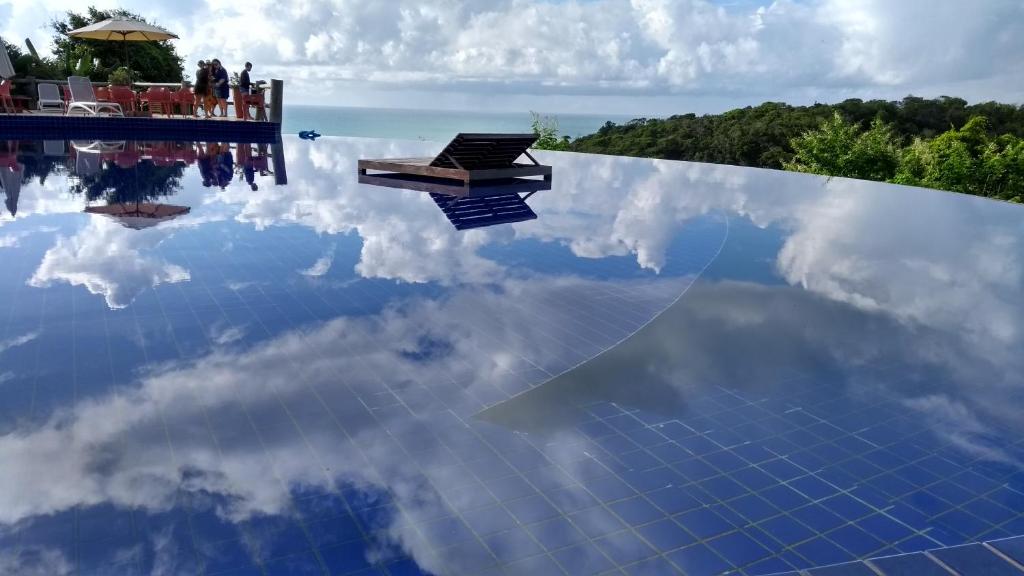 a reflection of the sky in a swimming pool at Bangalô no alto da colina no Villas do Pratagy - Maceió in Maceió