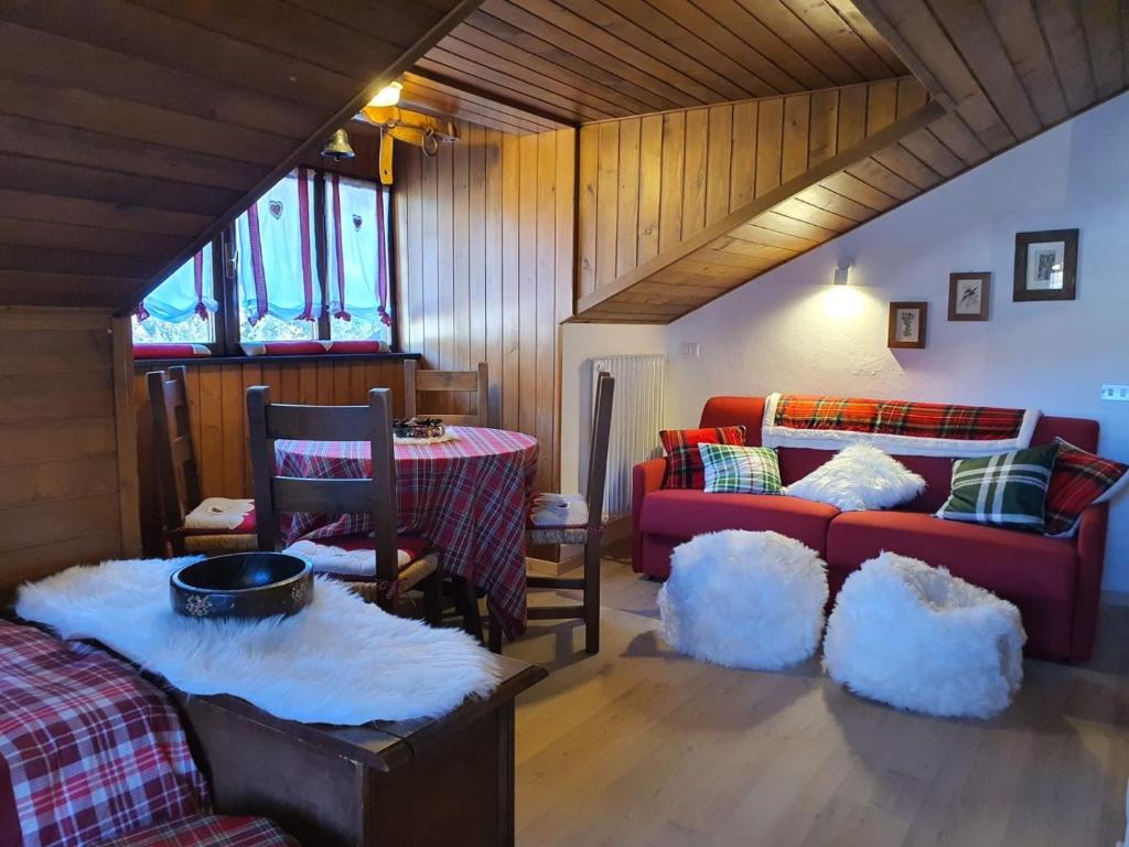 ein Wohnzimmer mit einem Sofa und einem Tisch in der Unterkunft DELIZIOSA MANSARDA in Madonna di Campiglio