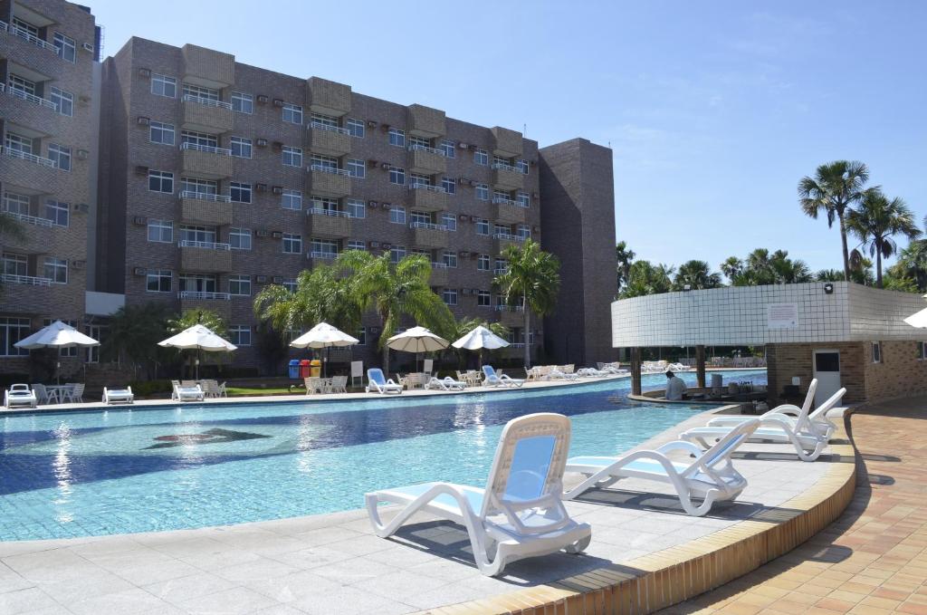 uma piscina com espreguiçadeiras e um hotel em Quarto em Gran Lençóis Flat Residence em Barreirinhas