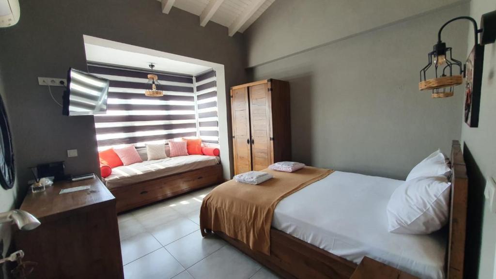 a bedroom with a bed and a couch in it at Signature Alaçatı in Alacati