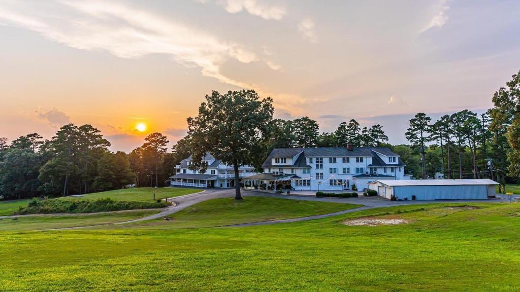 a house on a golf course with the sunset in the background at 1913 Badin Inn in Badin