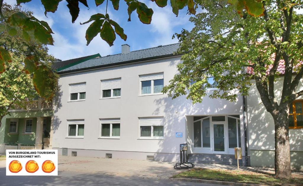 een wit gebouw met een boom ervoor bij Apartment-76 in Wallern im Burgenland