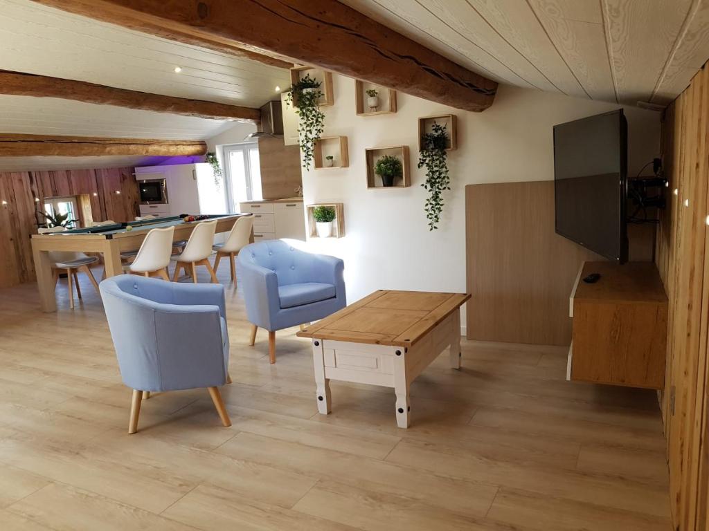 a living room with a table and chairs and a kitchen at La Vigne d'Aubière, Spa/Balnéo, Billard,Lit 2mx2m in Aubière