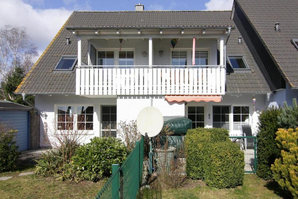 a white house with a white balcony at Ferienwohnung, Trassenheide in Trassenheide