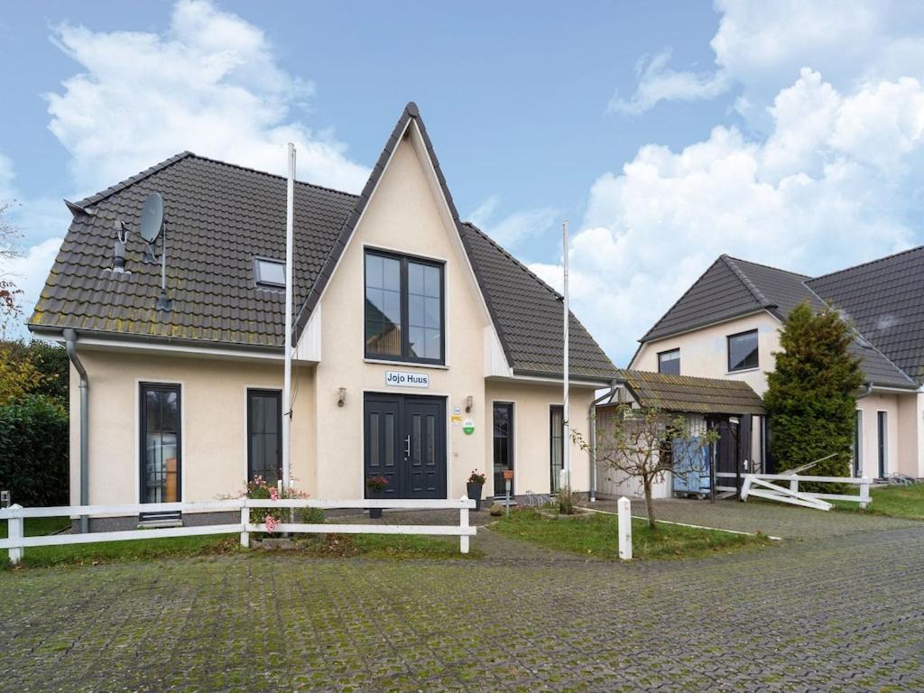 a house with a white fence in front of it at Pretty Holiday Home in Bastorf with Private Garden in Bastorf