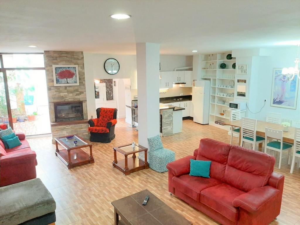 salon z czerwonymi kanapami i kuchnią w obiekcie LA CASA DE LA PINTORA DE CAZORLA,ideal para familias y grupos grandes w mieście Cazorla