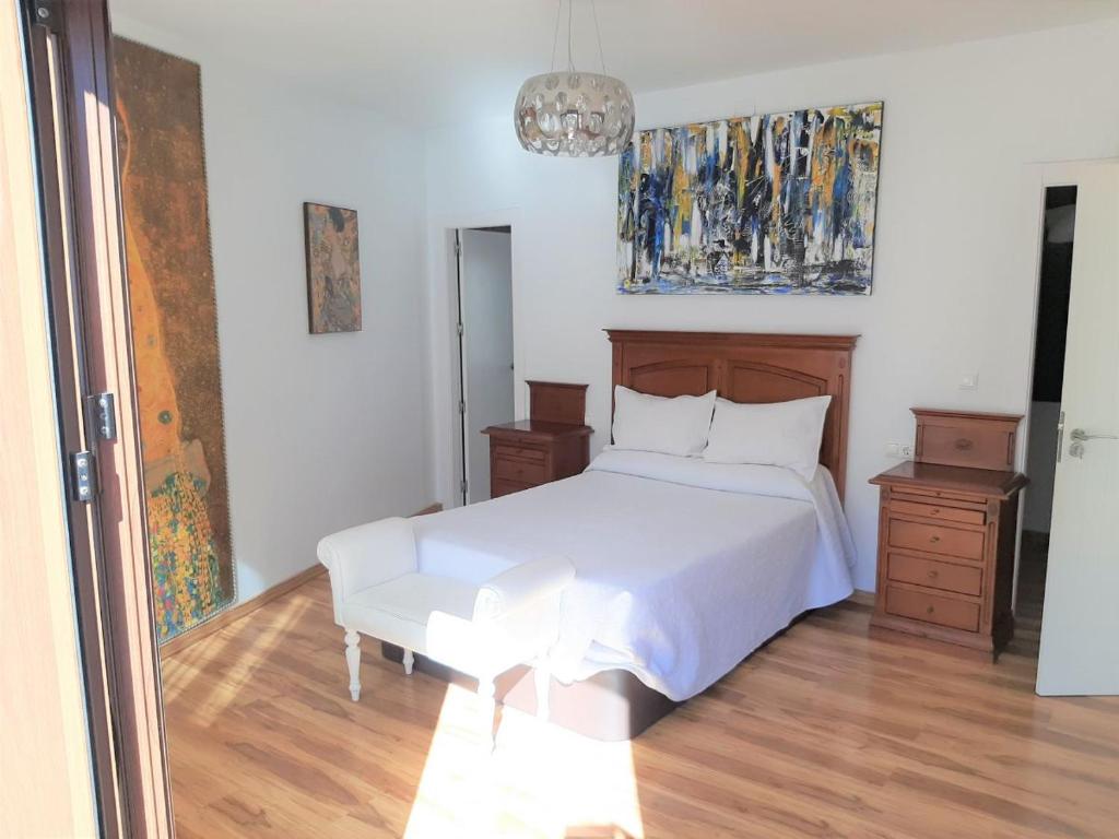 sypialnia z białym łóżkiem i drewnianą podłogą w obiekcie LA CASA DE LA PINTORA DE CAZORLA,ideal para familias y grupos grandes w mieście Cazorla