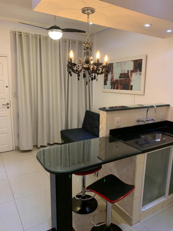 comedor con mesa de cristal y lámpara de araña en Jorge Adolfo Paiva Apartment, en Río de Janeiro