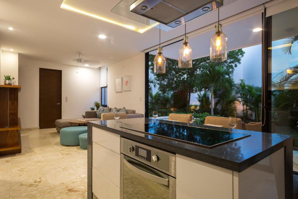 uma cozinha com um balcão e uma sala de estar em Lovely 1 Bedroom Condo with plunge pool In Bahia Principe Golf Resort em Akumal