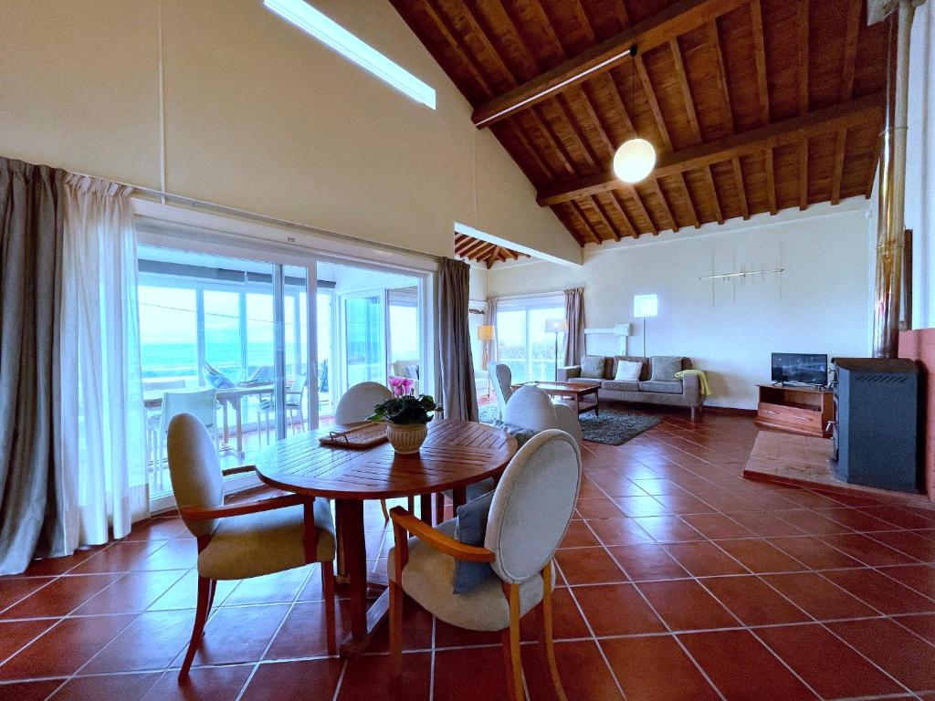 - un salon avec une table et des chaises en bois dans l'établissement Carpe Diem Azores, à Mosteiros