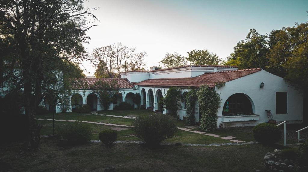 Casa blanca con techo rojo en Posada del Virrey en Merlo