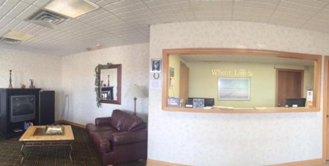 a living room with a couch and a tv at Sunflower Inn & Suites - Garden City in Garden City