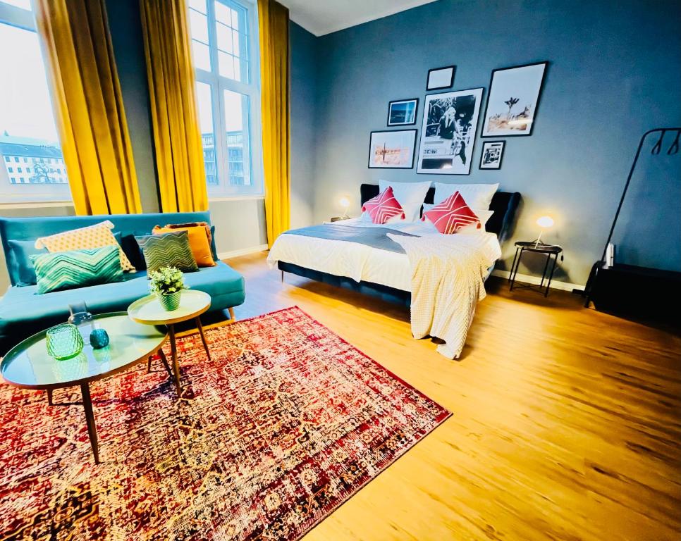 um quarto com uma cama, um sofá e um tapete em Klassen Stay - Exklusives Altbau Apartment - Zentral - Rheinnähe em Koblenz