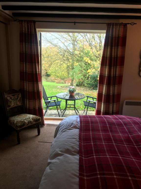a bedroom with a bed and a table and a window at The Stables in Ashover