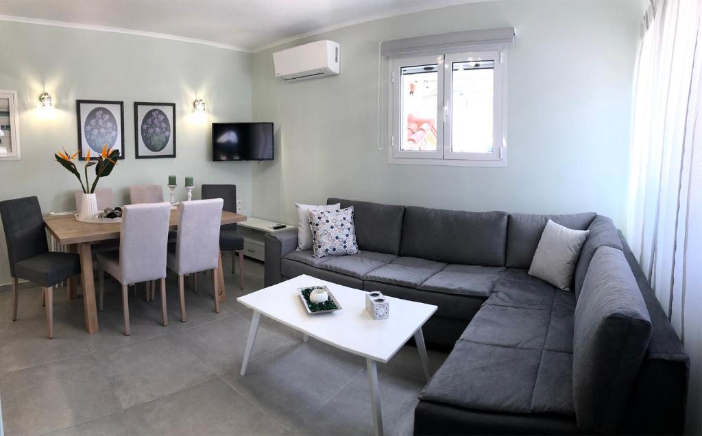 Strelitzia Apartments في Karavádhos: غرفة معيشة مع أريكة وطاولة