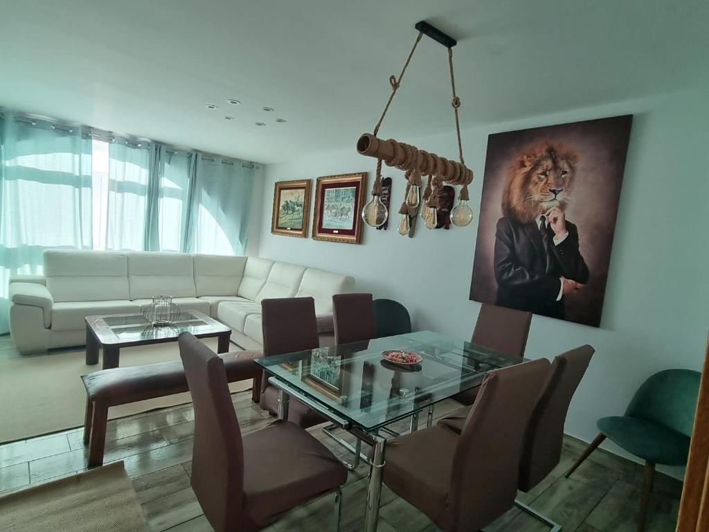 a living room with a table and a lion picture on the wall at Chalet Adosado Urbanización COPOS PREMIUM Zona Media in Sierra Nevada