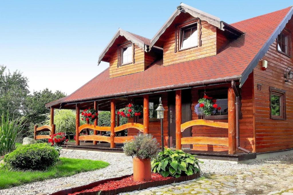 a wooden house with flowers in front of it at holiday home, Miedzyzdroje in Międzyzdroje