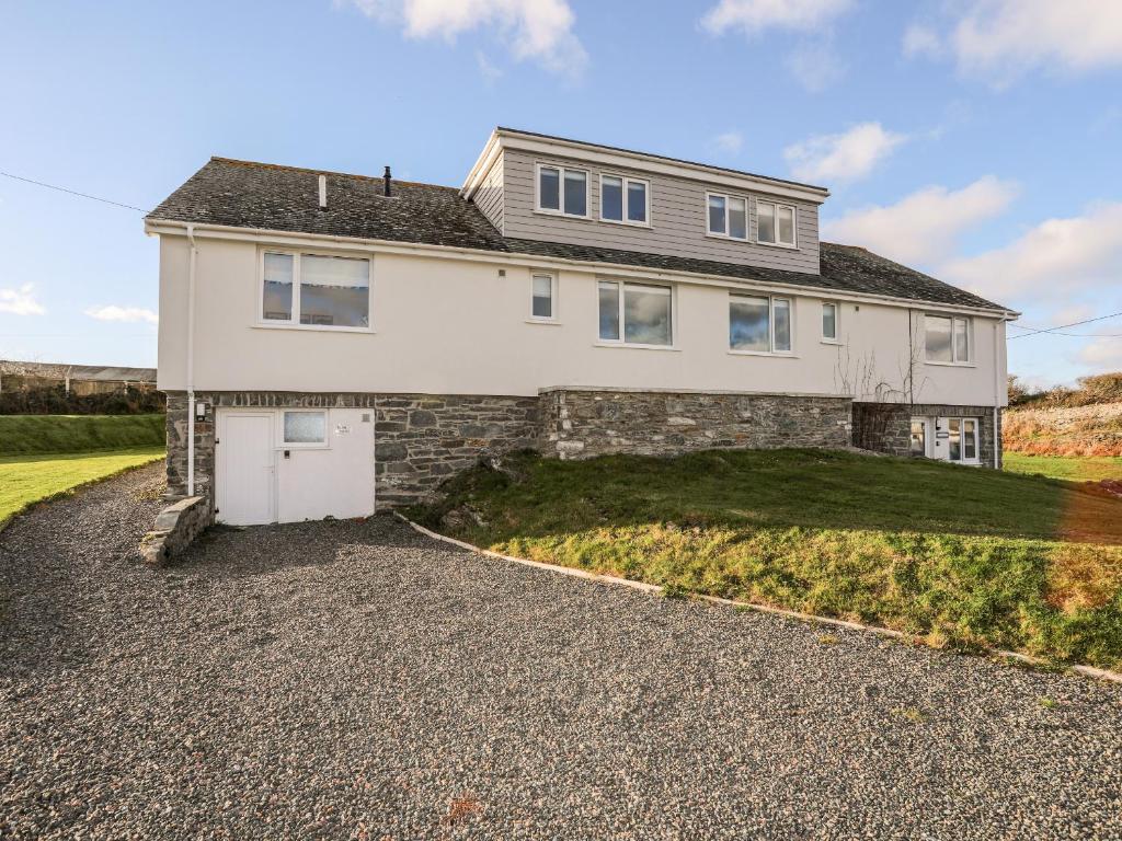 a large white house with a driveway at Burton Apartment in Trearddur