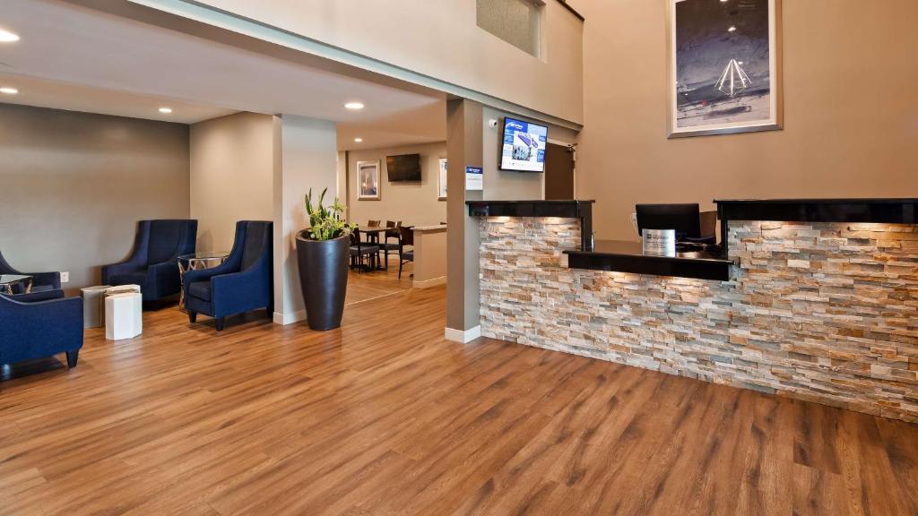 a lobby with blue chairs and a brick wall at Best Western La Plata Inn in La Plata