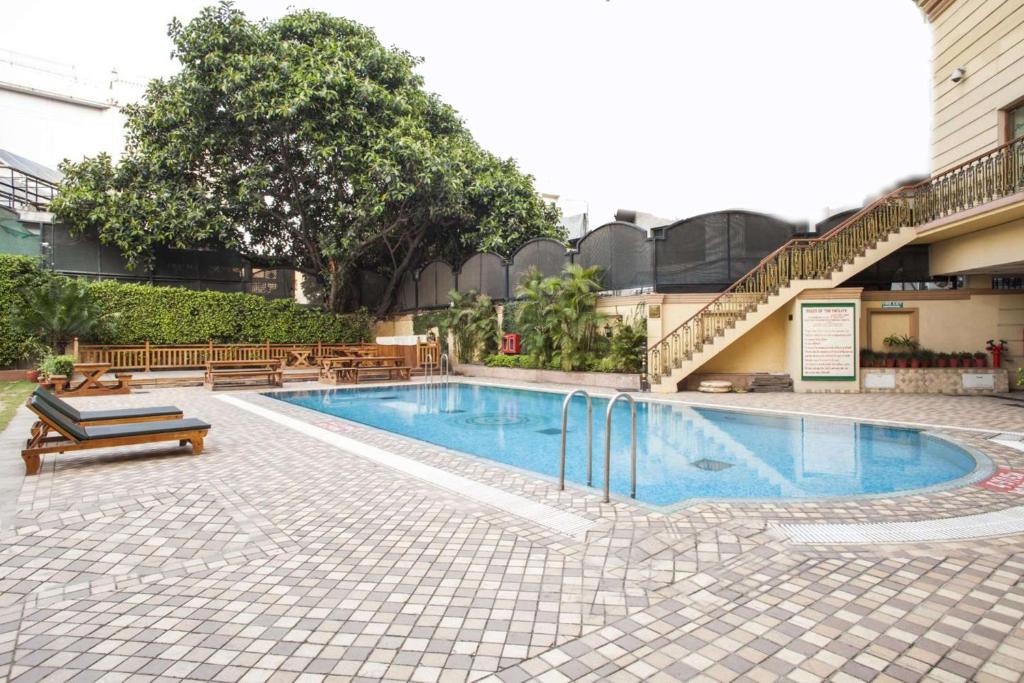 una piscina con bancos junto a un edificio en Radisson Hotel Jalandhar, en Jalandhar