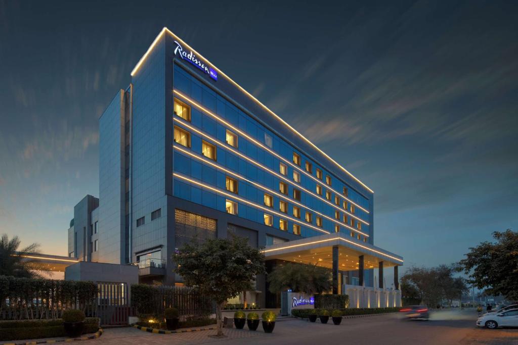 a tall blue building with a sign on it at Radisson Blu Faridabad in Faridabad