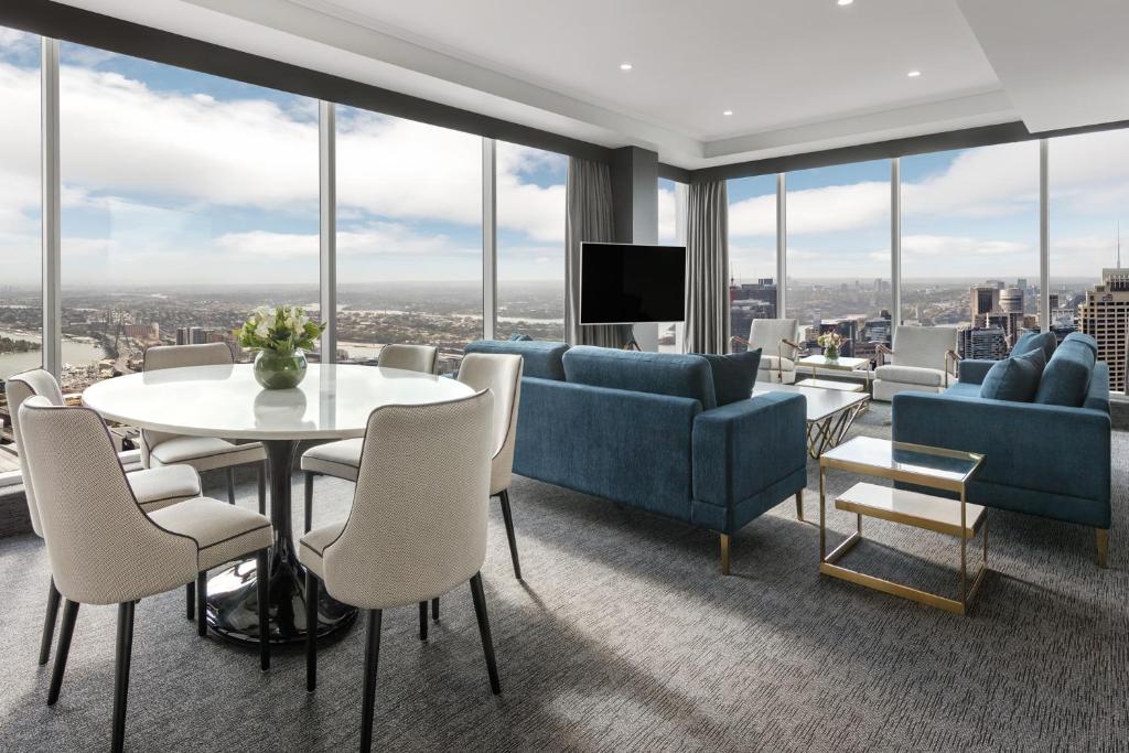 シドニーにあるMeriton Suites World Tower, Sydneyのリビングルーム(青い家具、テーブル、椅子付)