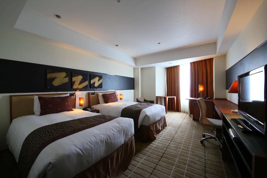 Postel nebo postele na pokoji v ubytování International Resort Hotel Yurakujo