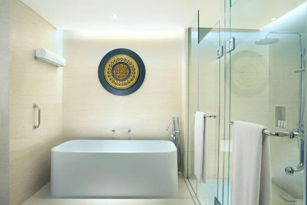 a bathroom with a white sink and a glass shower at Radisson Lampung Kedaton in Bandar Lampung