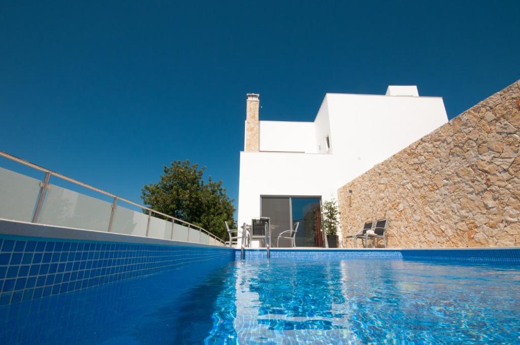 a swimming pool in front of a white villa at Casa da Ribeira in Silves