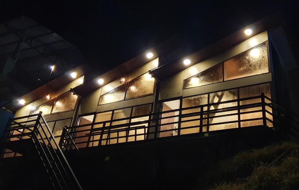 a building with lights on the side of it at night at Into The Wild Stays in Dhanaulti