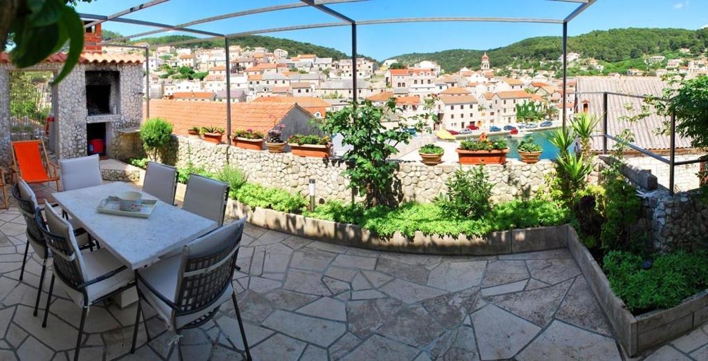 een patio met een tafel en stoelen en uitzicht op de stad bij Holiday home Žarko - 50m to the sea in Pučišća