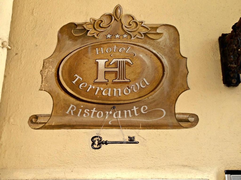 una señal para un hotel ragnarosyrinthennis en una pared en Hotel Terranova en Olbia