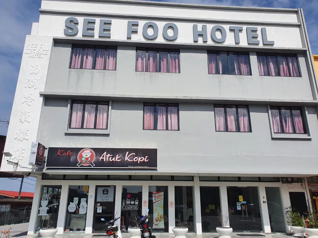 un grand bâtiment blanc avec un hôtel dans l'établissement See Foo Hotel, à Bidur