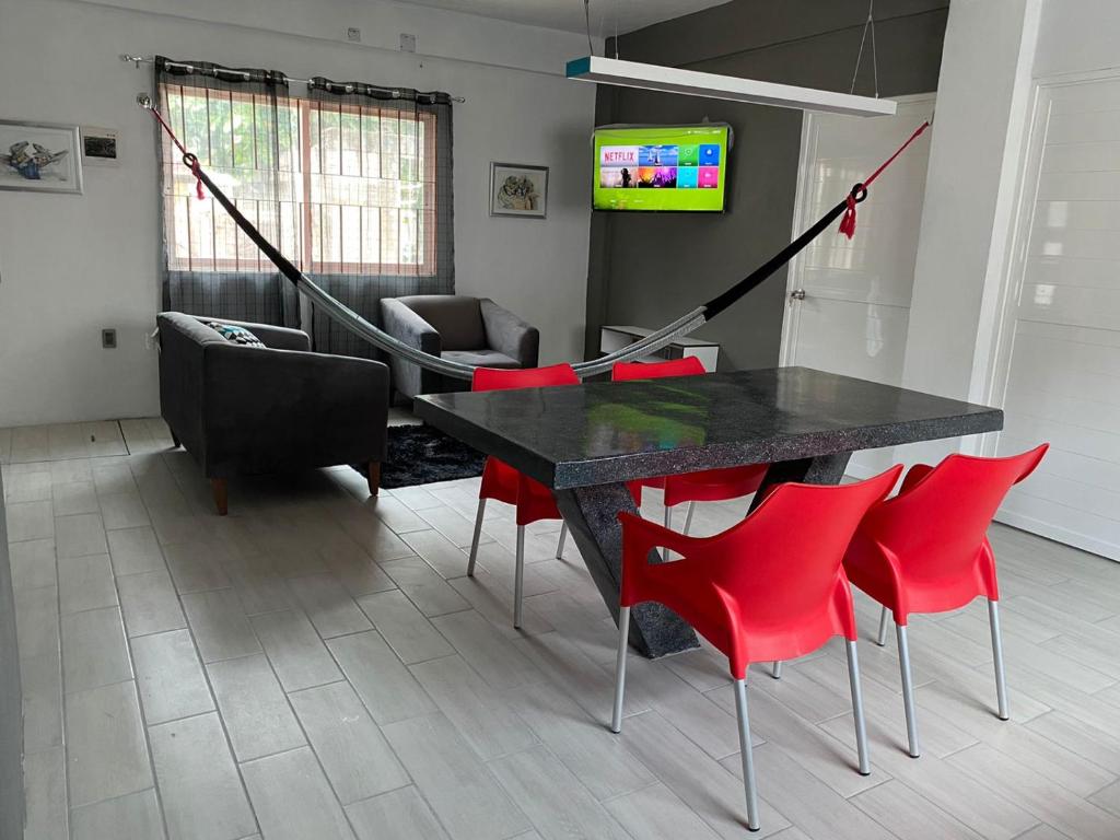 - un salon avec une table noire et des chaises rouges dans l'établissement Lidxi Angela, à Juchitán de Zaragoza