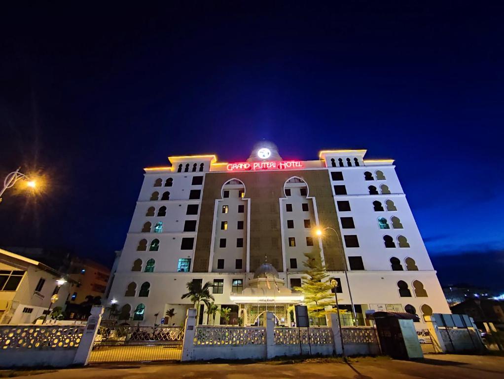 a hotel building with a sign on it at night at The Grand Puteri Hotel in Kuala Terengganu