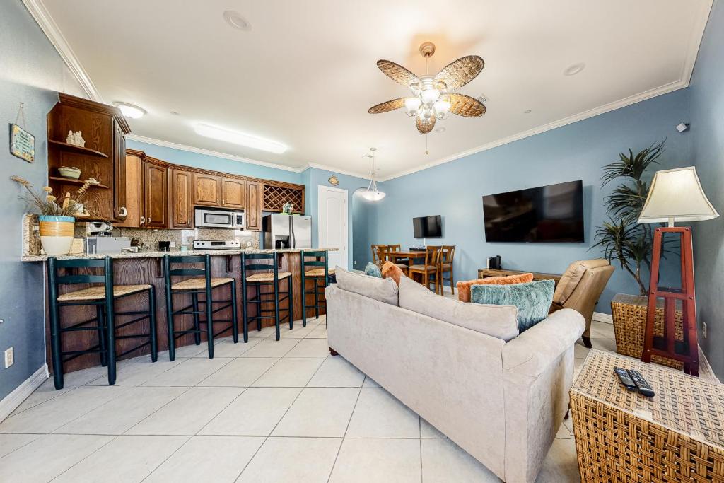 a living room with a couch and a kitchen at Saturn Serenity & Condo in South Padre Island