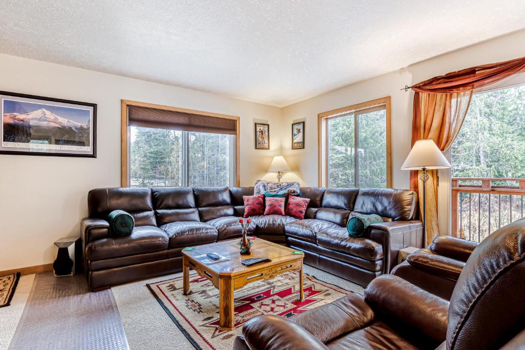 a living room with leather couches and a table at Alltitude Chalet in Government Camp