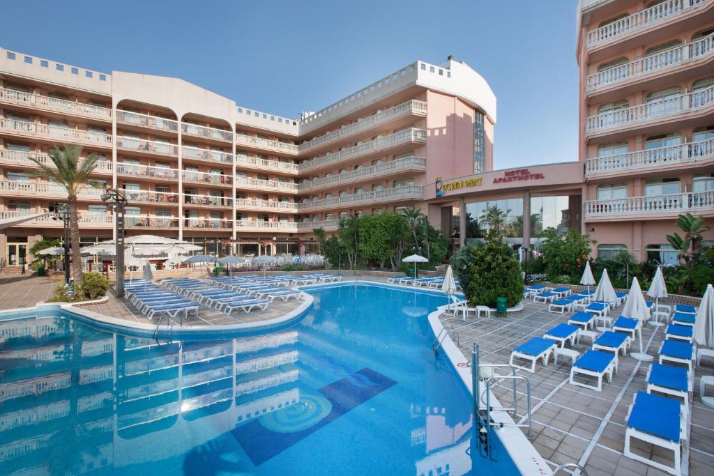 a resort with a swimming pool and chairs and a hotel at Hotel-Aparthotel Dorada Palace in Salou
