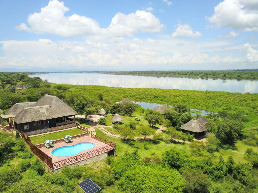 Murchison Falls National ParkにあるTwiga Safari Lodgeのスイミングプールと湖のあるリゾートの空中ビュー